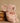 Plush elephant toy with a pink bow sitting next to a woven basket on a beige background