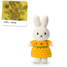 Crocheted bunny toy in a yellow dress with a matching book on a white background