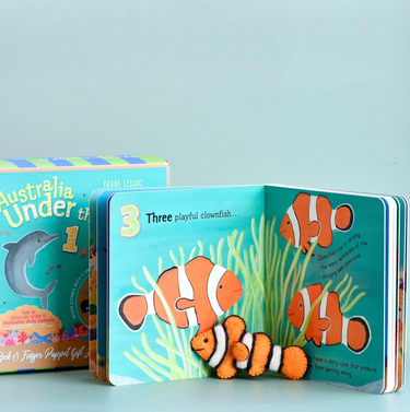 Children's book with clownfish illustration and clownfish finger puppet on a light blue background