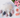 Decorative cloud with teardrop-shaped raindrops on a white surface with flowers and macarons.