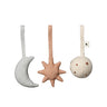 Three Ferm Living soft fabric baby hanging toys on a white background: a pale gray crescent moon, a dusty peach star, and an off-white round ball with small star cutouts.