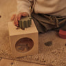 Child playing with Ferm Living building blocks on a carpeted floor