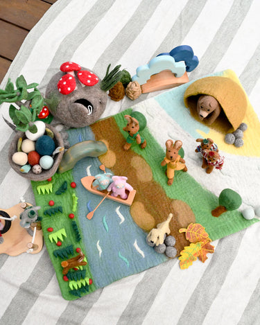 Felt playset with animals and nature elements on a striped fabric background