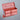 Red toolbox on a reflective surface with a gray background