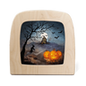 A square wooden lamp with rounded corners, featuring a Halloween night scene printed in the center. The artwork shows a witch riding a broomstick under a full moon near a haunted house, with bare trees, bats, and three glowing jack-o'-lantern pumpkins in the foreground.