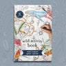 An activity book with a child's hand on a blue background with pictures of flowers 