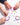 Hands making colorful bracelets with charms on a white background