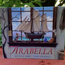 Book titled 'Arabella' with a sailboat illustration on the cover, surrounded by greenery.