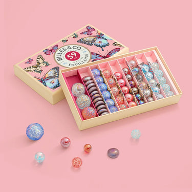 Balls & Co. marble set in a decorative box on a pink background