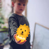 Child holding a lion-shaped night light in a blurred indoor setting