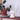 White dog-shaped lamp on a wooden shelf with plants in the background