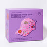 A lavender purple product box for 'Journey of Something' brand, featuring a pink baseball cap decorated with colorful flowers, hearts, and the name 'Kate' on the front, set against a clean white background.