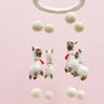 Plush llama mobile with pom-pom balls on a pink background