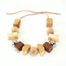 A wooden pram chain with beads and bells on a white background