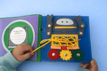 Children's felt activity book with a robot and colourful gears on a blue background
