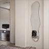 Wavy mirror on a wall with a minimalistic interior setting