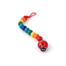 A colourful wooden dummy clip with a ladybird head on a white background