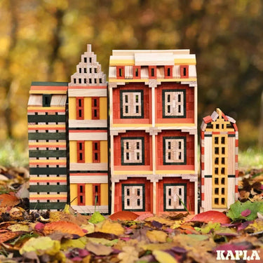 Structures made using the Kapla Wooden Building Planks 200 Autumn Set Box, set amongst autumn leaves.