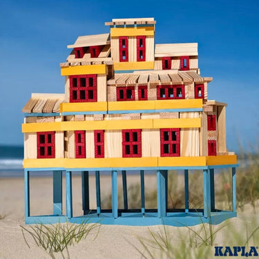 A multi story house made with the Kapla Wooden Building Planks in the 200 Plank Summer Box Set on the beach