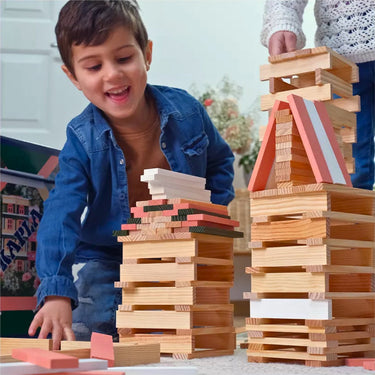 Child playing with wooden blocks, building towers indoors.