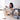 Child playing with a geometric wooden toy in a room with a large window.