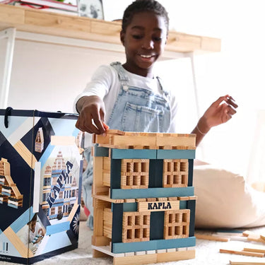Child playing with Kapla wooden building blocks in a bright room