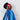 Child wearing a superhero costume with a blue cape and red mask against a white background