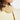 Close-up of a child wearing a beige outfit with gold fringe details.