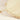 Close-up of a cream-colored fabric cushion with a fringed border and a lion tail, set against a matching cream background.