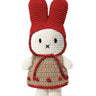 Crocheted toy resembling a character with a red hood and beige body on a white background