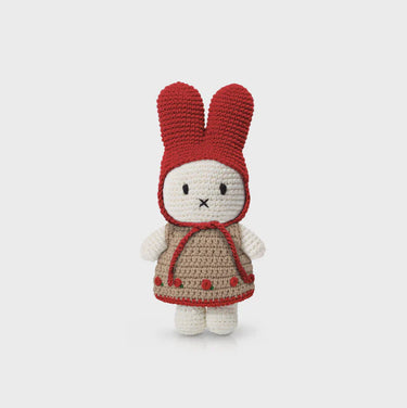 Crocheted toy rabbit with a red hood and beige body on a light gray background