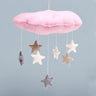 Pink cloud-shaped mobile with hanging stars on a light blue background