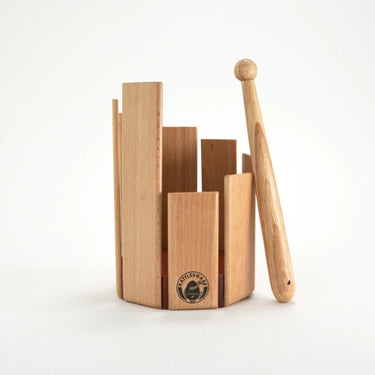 A wooden drum with different height levels and a drumstick on a white background  